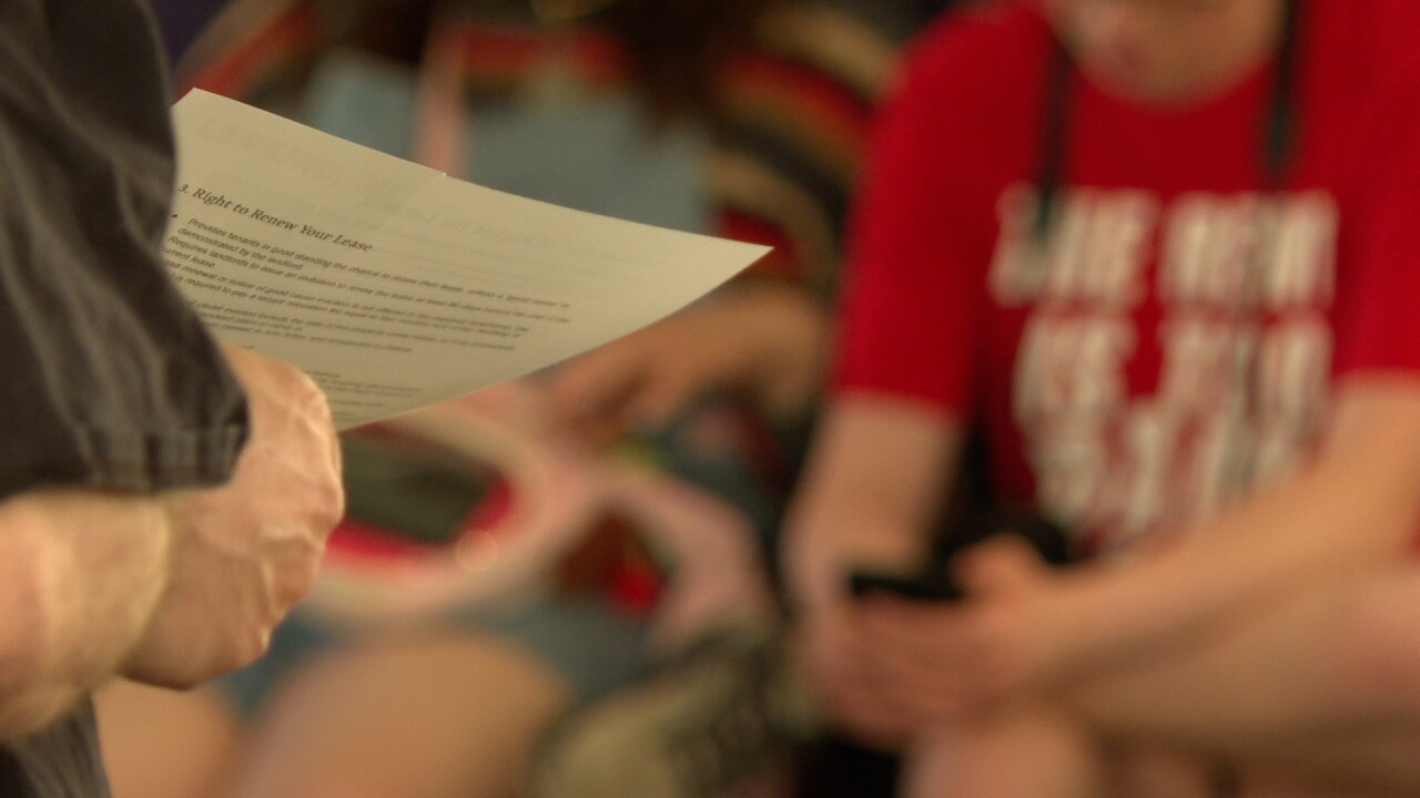 download Hands holding a paper agenda in front of a woman in a red shirt